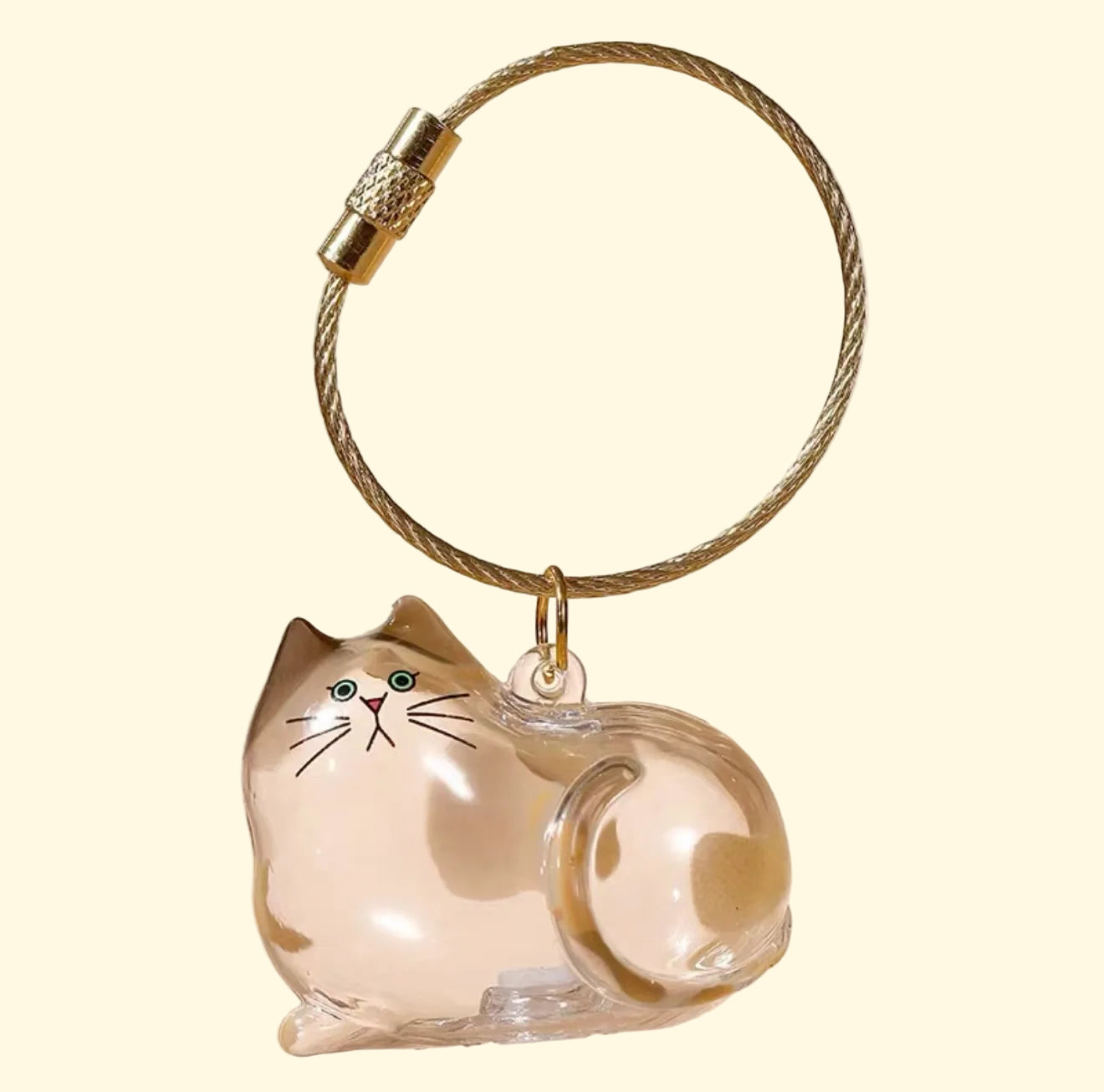 Llavero transparente con forma de gato sobre fondo beige